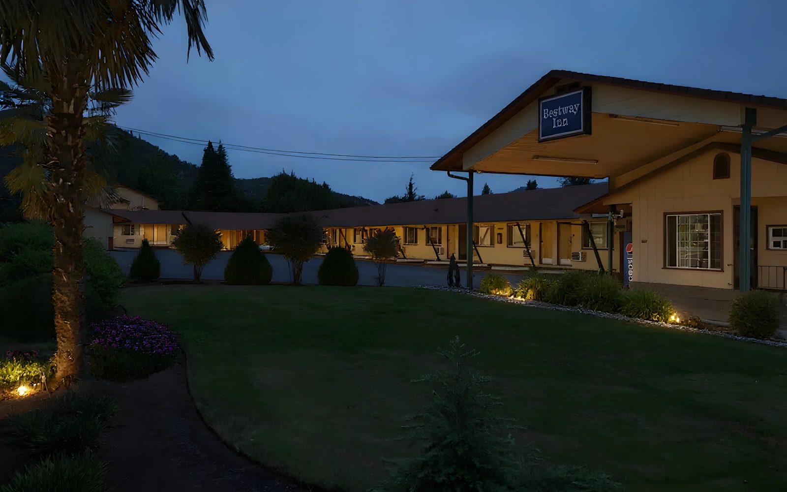Bestway Inn at dusk — garden courtyard with warm path lighting