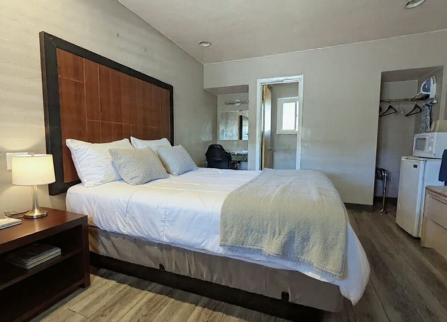 King Comfort room with a tall wood headboard and crisp white bedding